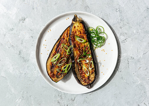 Roasted eggplant with miso ginger sauce on white plate
