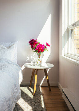 Bouquet of red peonies on bedside table