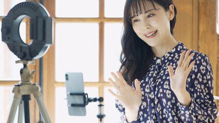 スマホで動画を撮る女性　ライバー　配信者　ユーチューバー　Vlog