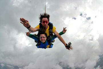 Skydiving tandem having fun on a cloudy day