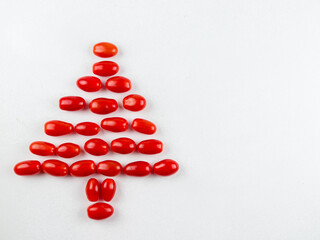 
red christmas tree made from tomato.

The creative red Christmas tree on the left is made from cherry tomatoes and there is room for text on the right, close-up top view.