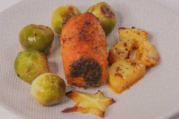 meatloaf and potatoes.

Meatloaf, Brussels sprouts and potatoes lie in a light plate on a wooden table, close-up side view.