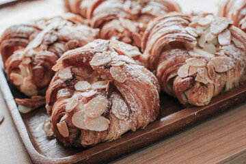 Almond Croissant Bakery homemade on the Table. Traditional French breakfast tray with gold and crispy croissants.