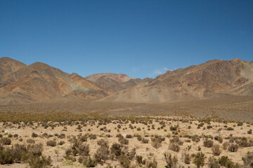 Fototapeta na wymiar The Andes mountain range. View arid desert, rock and sandstone mountains under a blue sky.