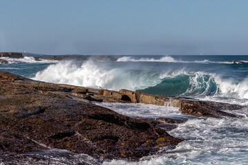 Powerful waves crashing onto rocks at Boat Harbour, Port Stephens, NSW, Australia