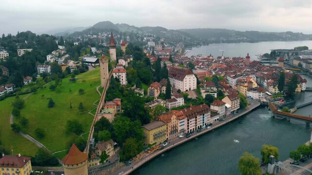 Aerial view over the Reuss river, towards the city of Luzern, cloudy, summer day, in Switzerland - dolly, drone shot