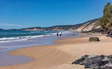 Father & son walking on Rainbow Beach, QLD, Australia - southern gateway to Fraser Island