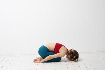 the girl is engaged in yoga on a light background Red T-shirt gesticulating with his hands