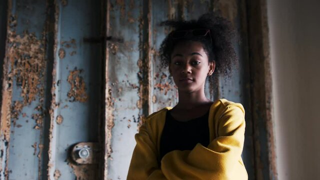 Portrait of mixed-race teenager girl standing indoors in abandoned building.