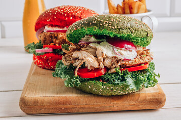 Homemade various chicken burger with colorful buns, kale, red onion, tomato and mayonnaise sauce
