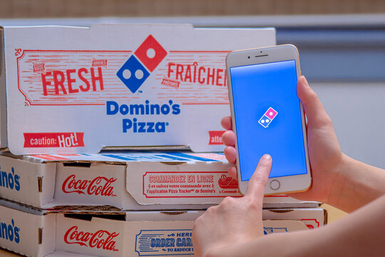Calgary, Alberta. Canada Dec 26, 2019. Close up of a person using the Domino&rsquo;s Pizza application on an iPhone Plus. Domino&rsquo;s Pizza sticking to growth plan despite sales pressures. Illustrative