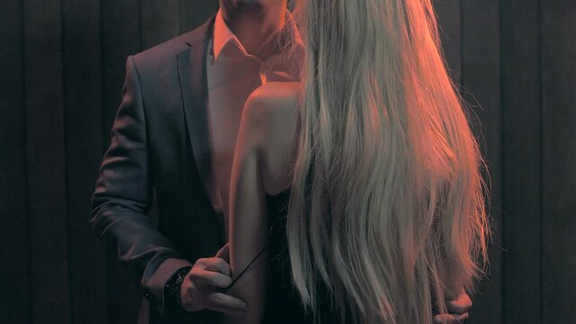 Handsome man removing dress strap from woman's shoulder