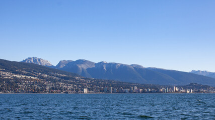 A view of North Vancouver's snow-capped mountains in the late fall, as the leaves start to change color. Taken from a sailboat in Burrard Inlet.