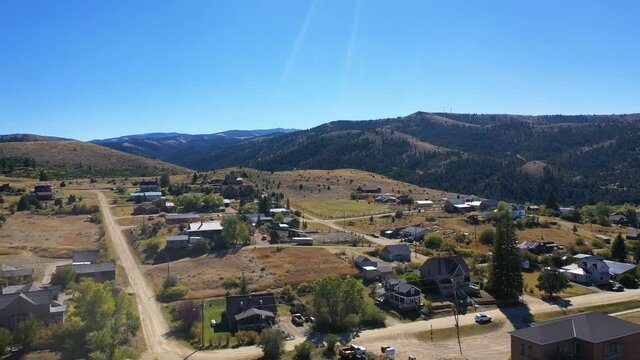 Aerial-Pulling back from view of small town in the mountains of Southwest Montana to the cemetery on a hill overlooking the historic mining town of  Virginia City, Montana
