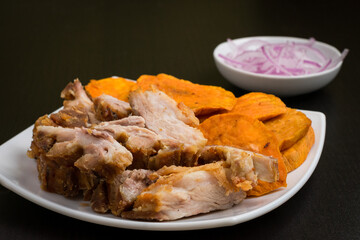 Porción de chicharron de cerdo y salsa criolla de cebolla