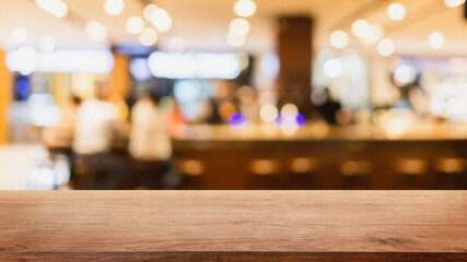 Empty wood table top and blurred coffee shop and restaurant interior background - can used for display or montage your products.