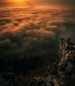 man standing on mountain top in autumn watching sunrise