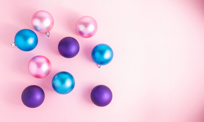 Satin, pink, purple and light blue Christmas balls on a pink background