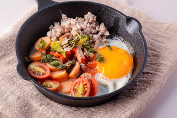Pan-fried eggs in a black pan on a gray background.