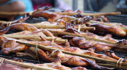 Roast chicken is on the stove, using charcoal to cook.