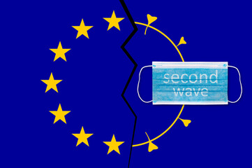 Protective face mask on Europe union flag with inscription SECOND WAVE . Covid-19 outbreak around the world. The global economic crisis. Crash by coronavirus. Life in lockdown around the world
