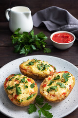 Baked potatoes in the peel stuffed with cheese with garlic and herbs.