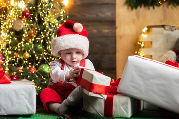 Christmas portrait of cute little baby in santa hat. Surprised kids face. Funny child New Year.