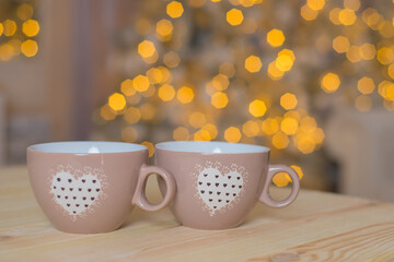 Obraz na płótnie Canvas cups with hot drink on new year bokeh background