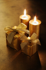 金色のラッピングをした二つのクリスマスプレゼントと日本のキャンドル
