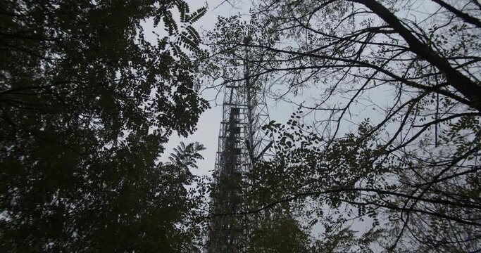 Looking Up The Trees With Duga Array In The Background At The Duga Radar Station In Chernobyl Exclusion Zone In Pripyat, Ukraine. Soviet over-the-horizon radar (OTH) system- low angle shot