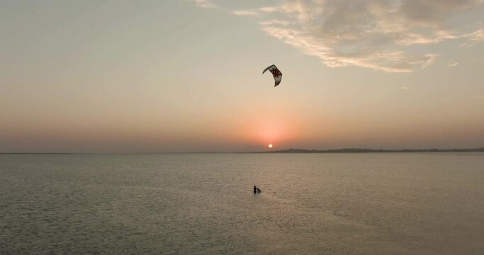 Aerial view towards a kite surfers taking a break, on lake Araruama, sunny evening, in Arubinha, Rio de Janeiro, Brazil -  dolly, drone shot 