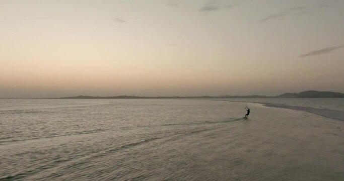 Aerial view of a kite glider on the Araruama salt lagoon, sunny evening, in Arubinha, Rio de Janeiro, Brazil - tracking, drone shot 