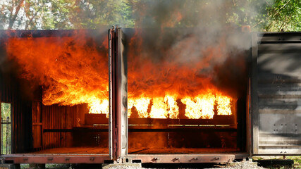 Firefighter fighting with flame using fire hose chemical water foam spray engine. Fireman wear hard...