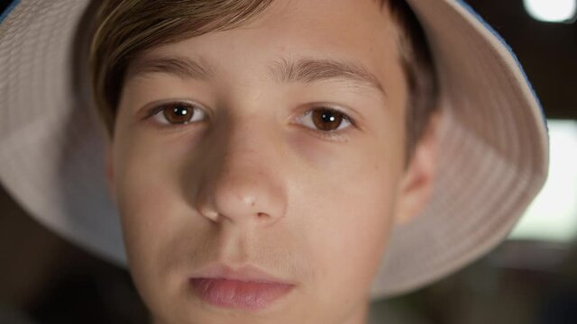 portrait of a serious boy in a hat looking at the camera indoors