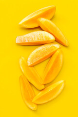 Tropical fruit, Mango  slices on yellow background.