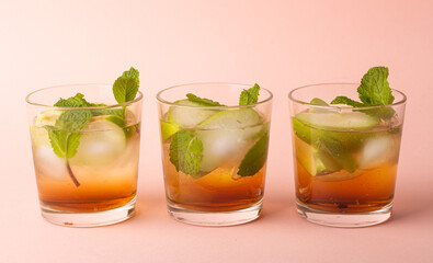 drinks with green apples, mint and ice on a pink background.