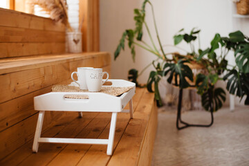 Close up of white tray with two cups on wooden steps