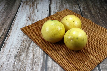 Pile of fresh and organic passion fruit on the wooden mat. Famous tropical fruit in Asia. Sour tasty and high vitamin concept. 