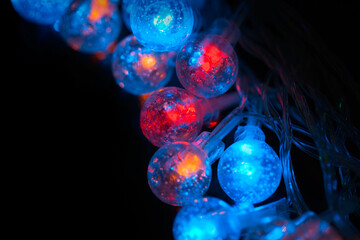 Beautiful Christmas garlands with led lights in glass balls on a black background