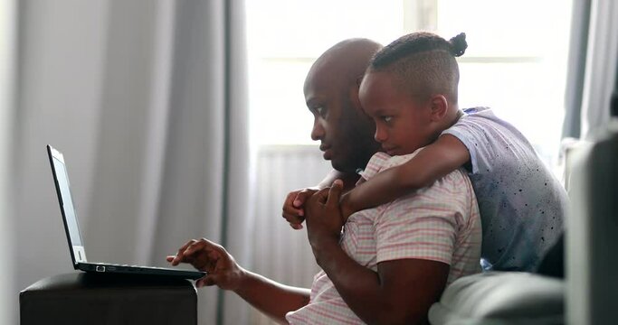 Black father working from home with child, african parent using laptop with son