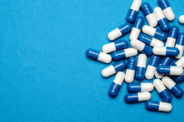 group of pills or capsules on blue background