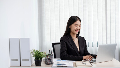 Asian businesswomen sit at their desks and calculate financial graphs showing results about their investments, plan a successful business growth process in the office