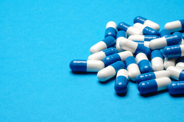group of pills or capsules on blue background