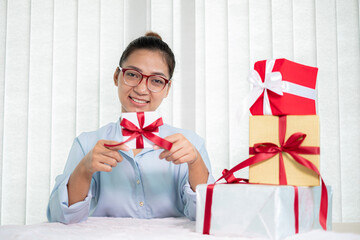 Asian woman holding a gift box Glad to be the giver of surprise with excitement, joy, and smiles on...