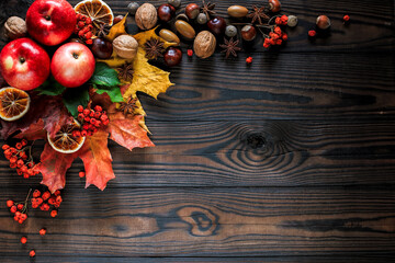 Autumn bright yellow-red leaves, nuts, apples on a wooden background. natural table made of boards. top view with space for text
