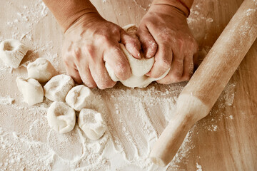 woman chef kneads the dough with her hands, female hands in flour, female chef holds the dough with her hands, female hands with dough
