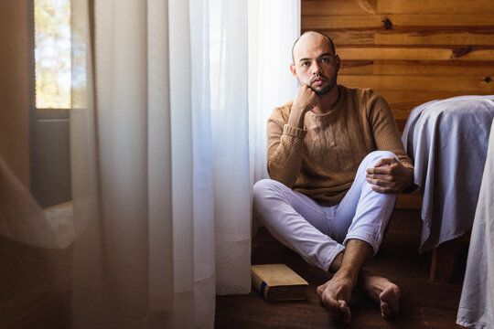 hombre pel&oacute;n con barba leyendo un libro con un su&eacute;ter para el frio