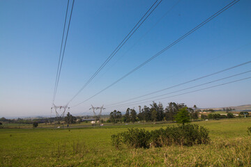 Power Lines Against Blue Sky Running Through Countryside