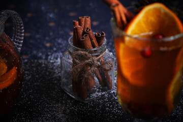 mulled wine tea with cinnamon and orange stands on a dark background