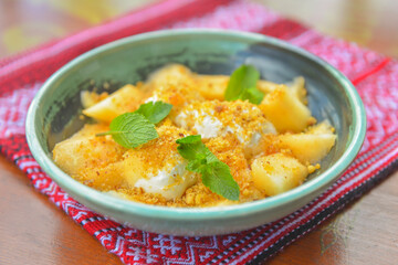 Delicious melon ice cream seved in a bowl over red table cloth. Sweet milk and fruit dessert for hot summer weather.